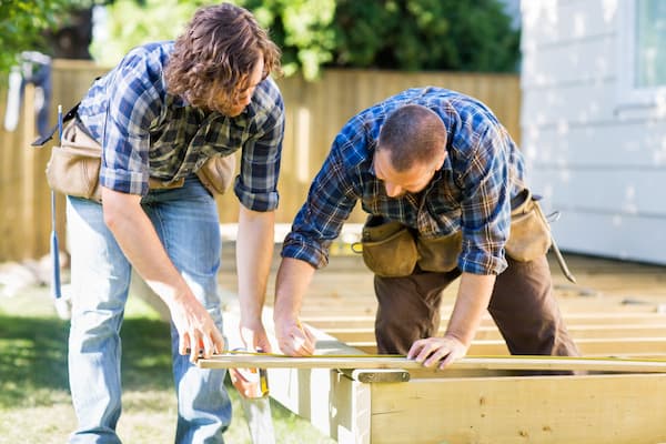 mid-adult-carpenter-marking-wood-while
